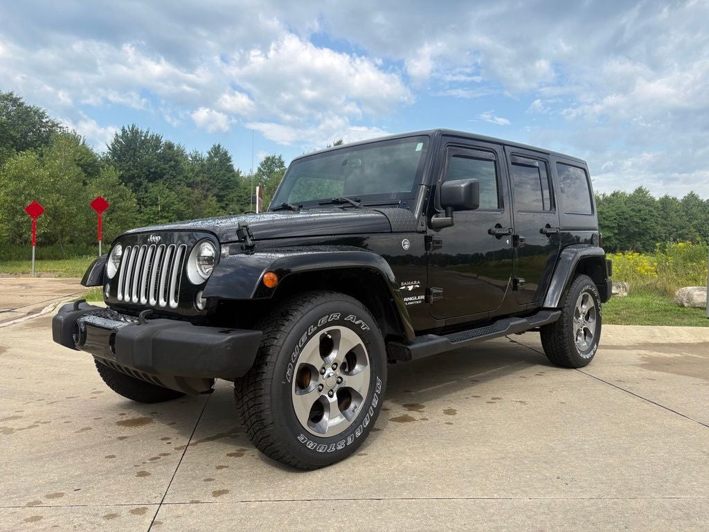 2017 Jeep Wrangler Unlimited Sahara in Black — front three-quarter view